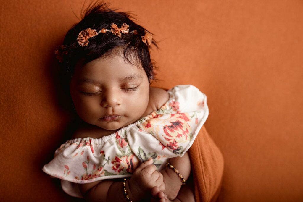 baby girl sleeps on a studio bed wearing a carnation dress Toronto Birthing Centre