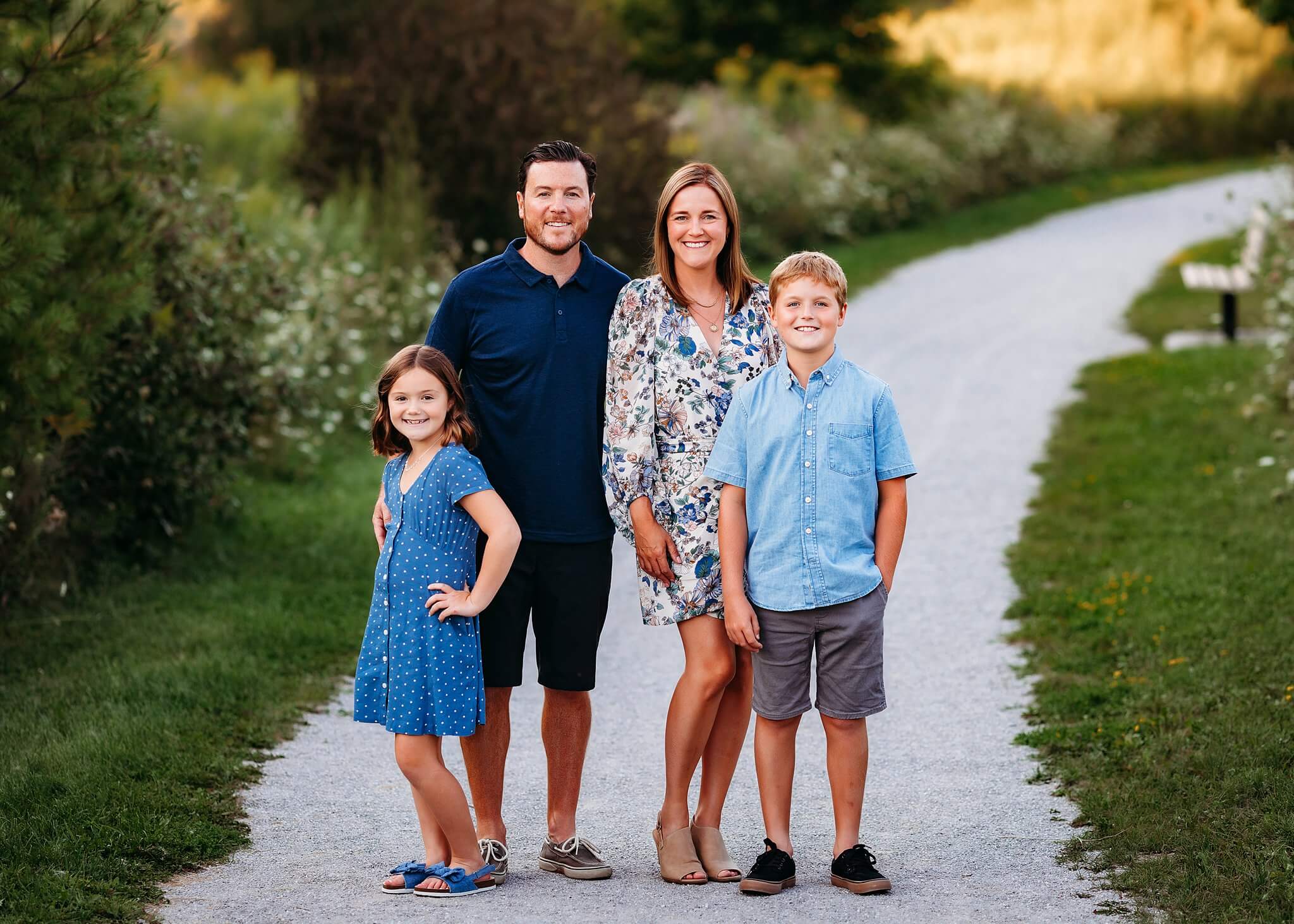 Family with a young son and daughter pose in the center of a pathway