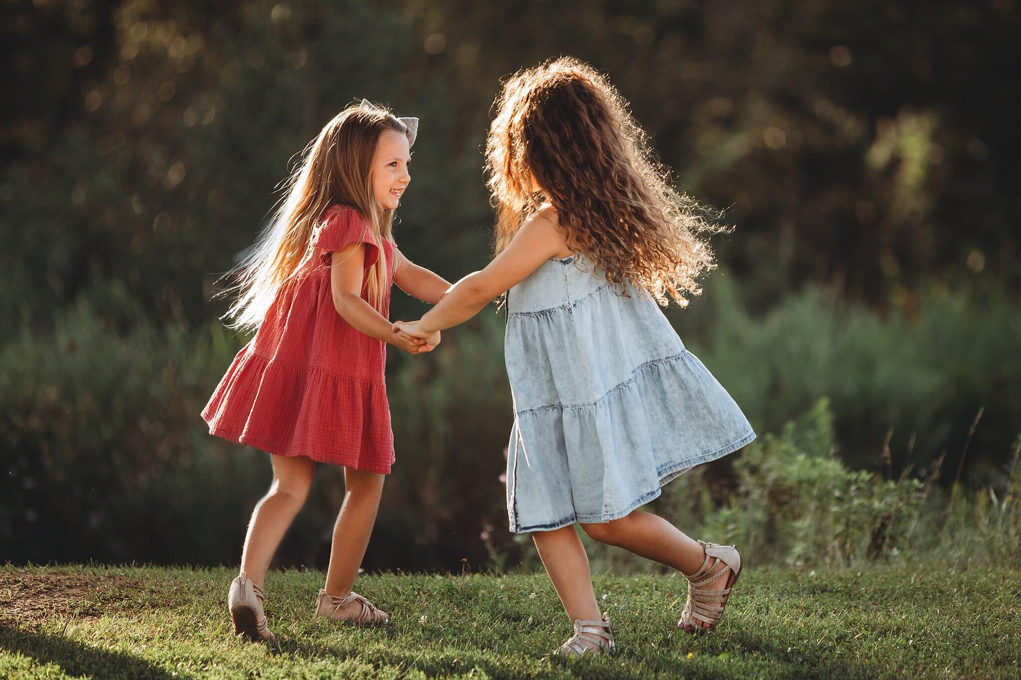 Young girls holding hands and dancing on the grass