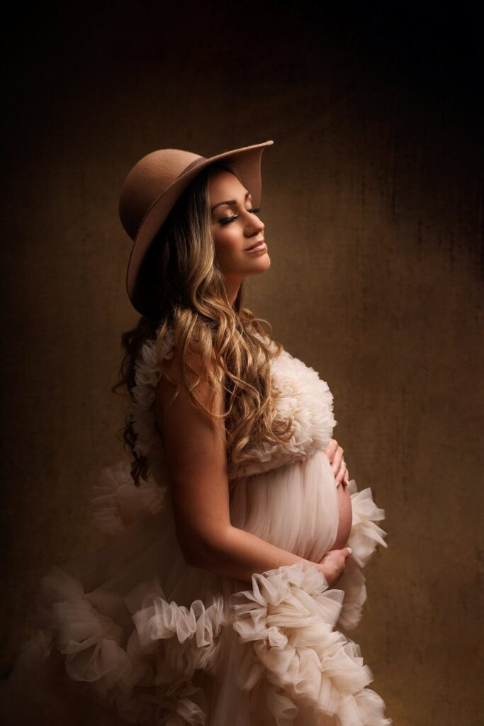 Pregnant mother in a beautiful gown and cute hat by Barrie Maternity Photographer