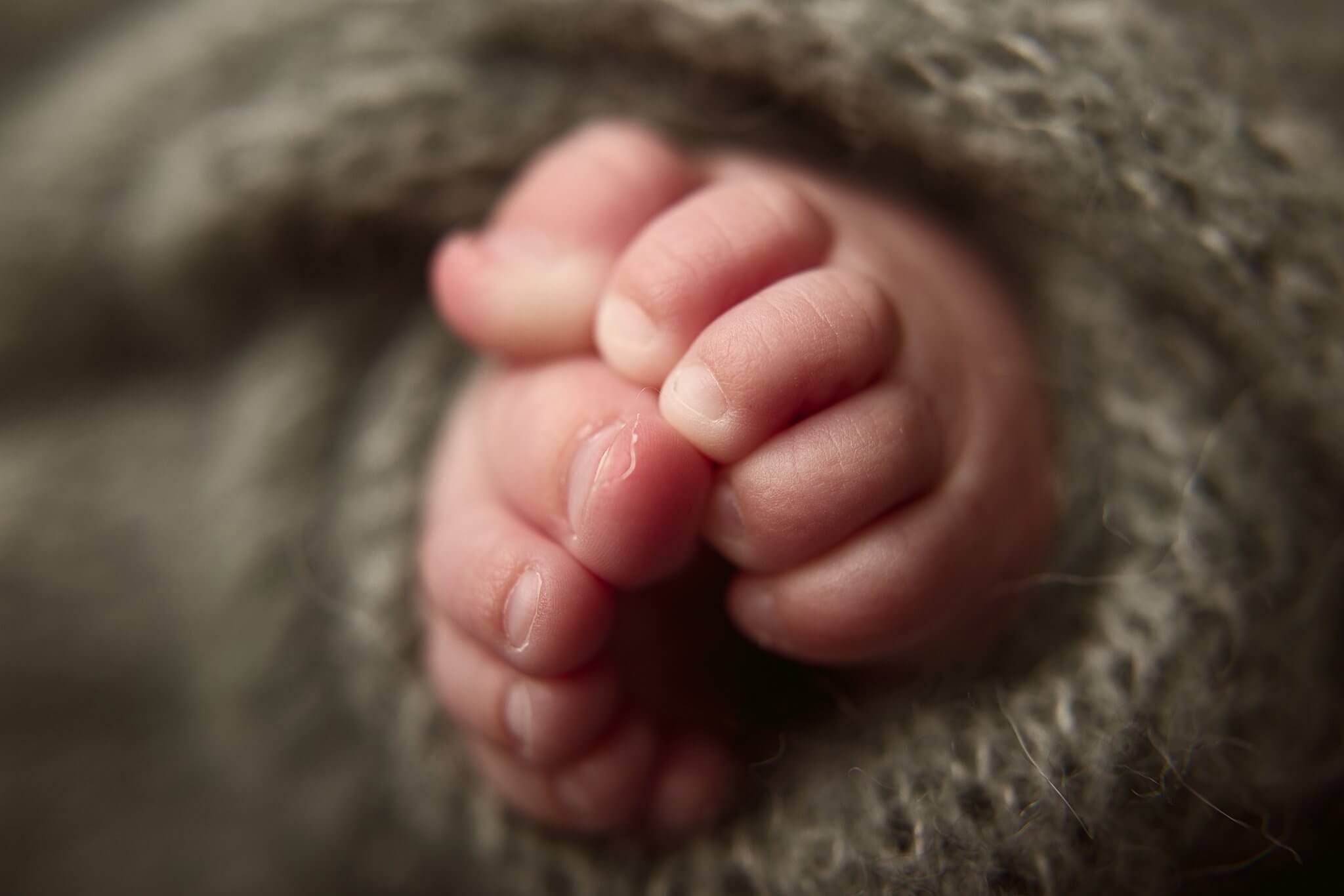 Tiny baby toes wrapped in sage