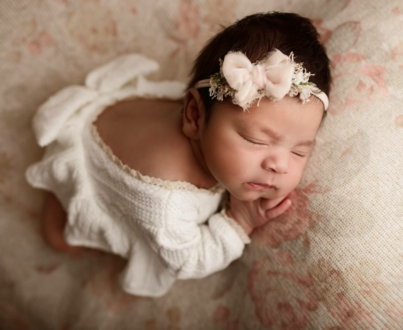 Baby girl on a vintage floral fabric