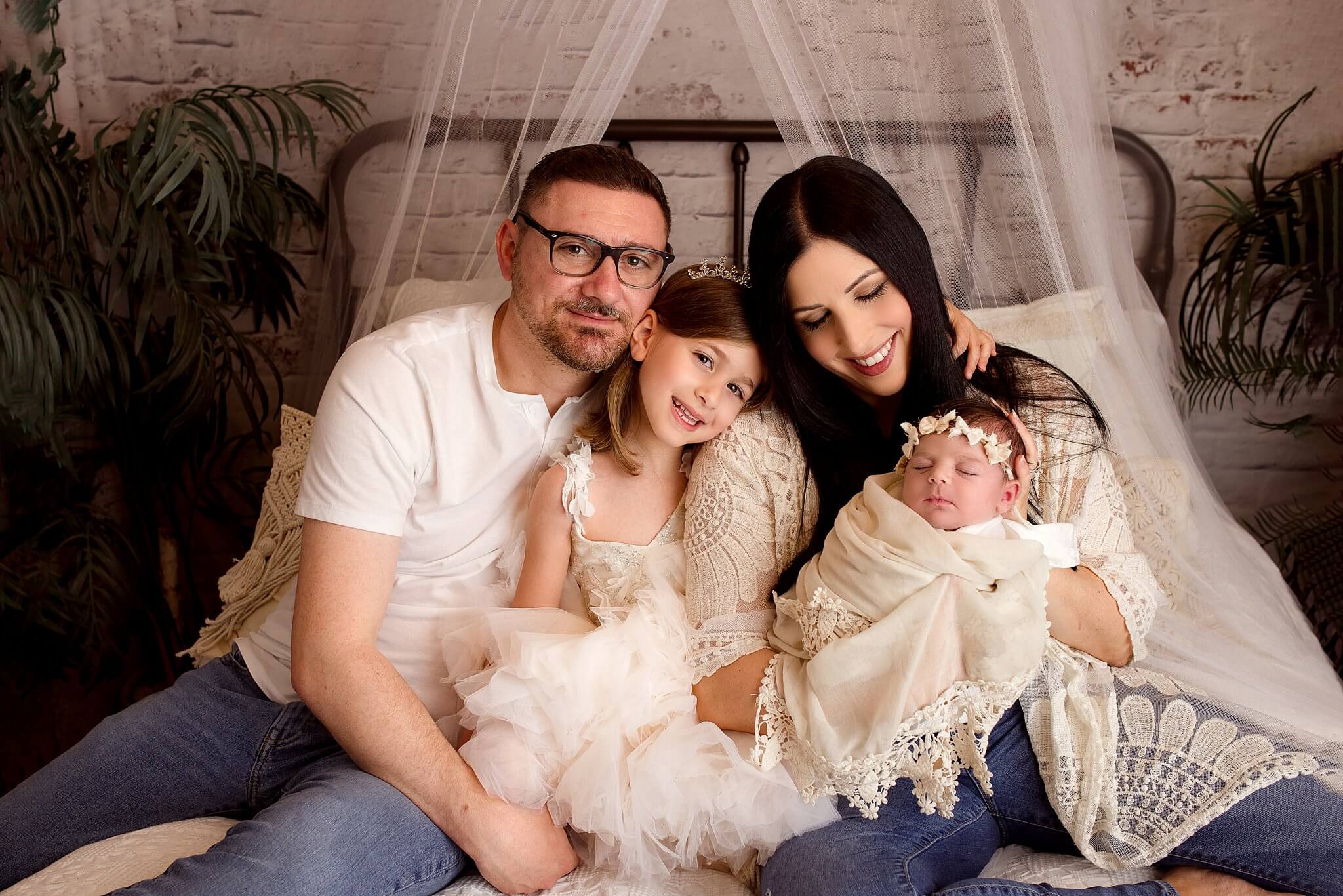 Family photo of parents and big sister with new baby girl