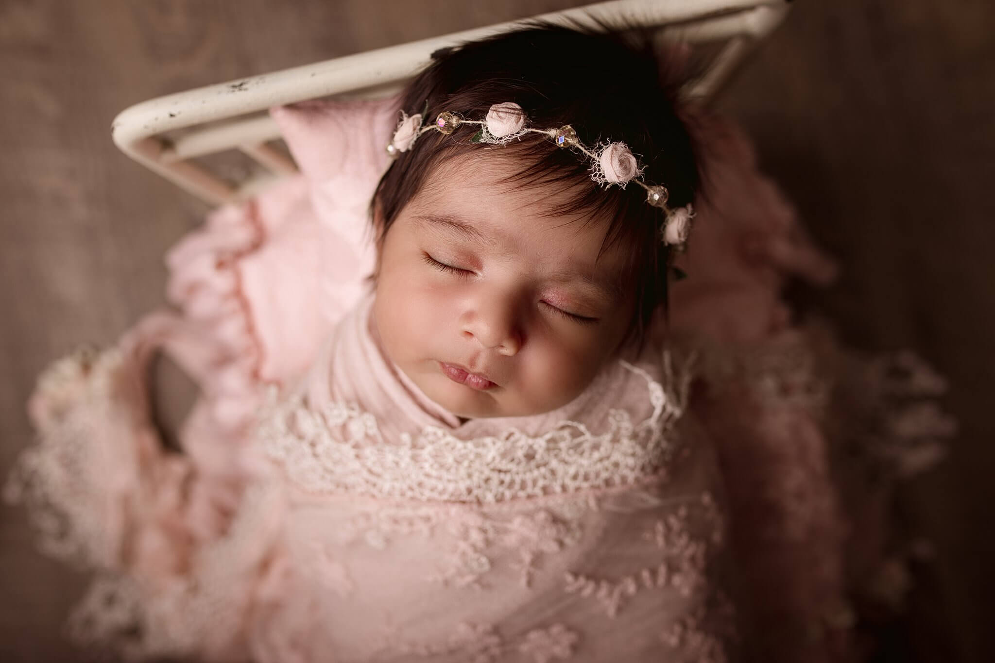 Sleeping Newborn baby girl wrapped in pink lace