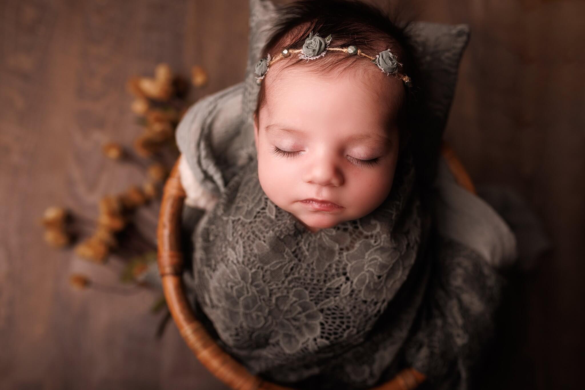 Newborn baby girl in dark sage lace with a tiny headband