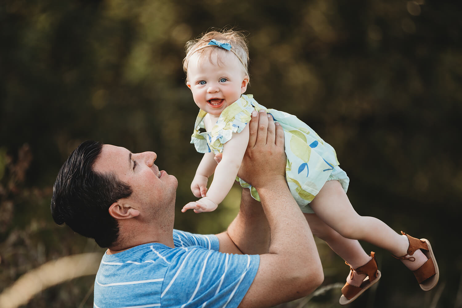 Outdoor family session of father with baby daughter.