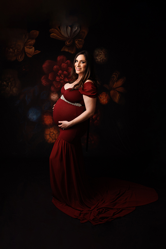 Toronto Maternity Photographer Mom to be in a fitted red gown smiling at the camera