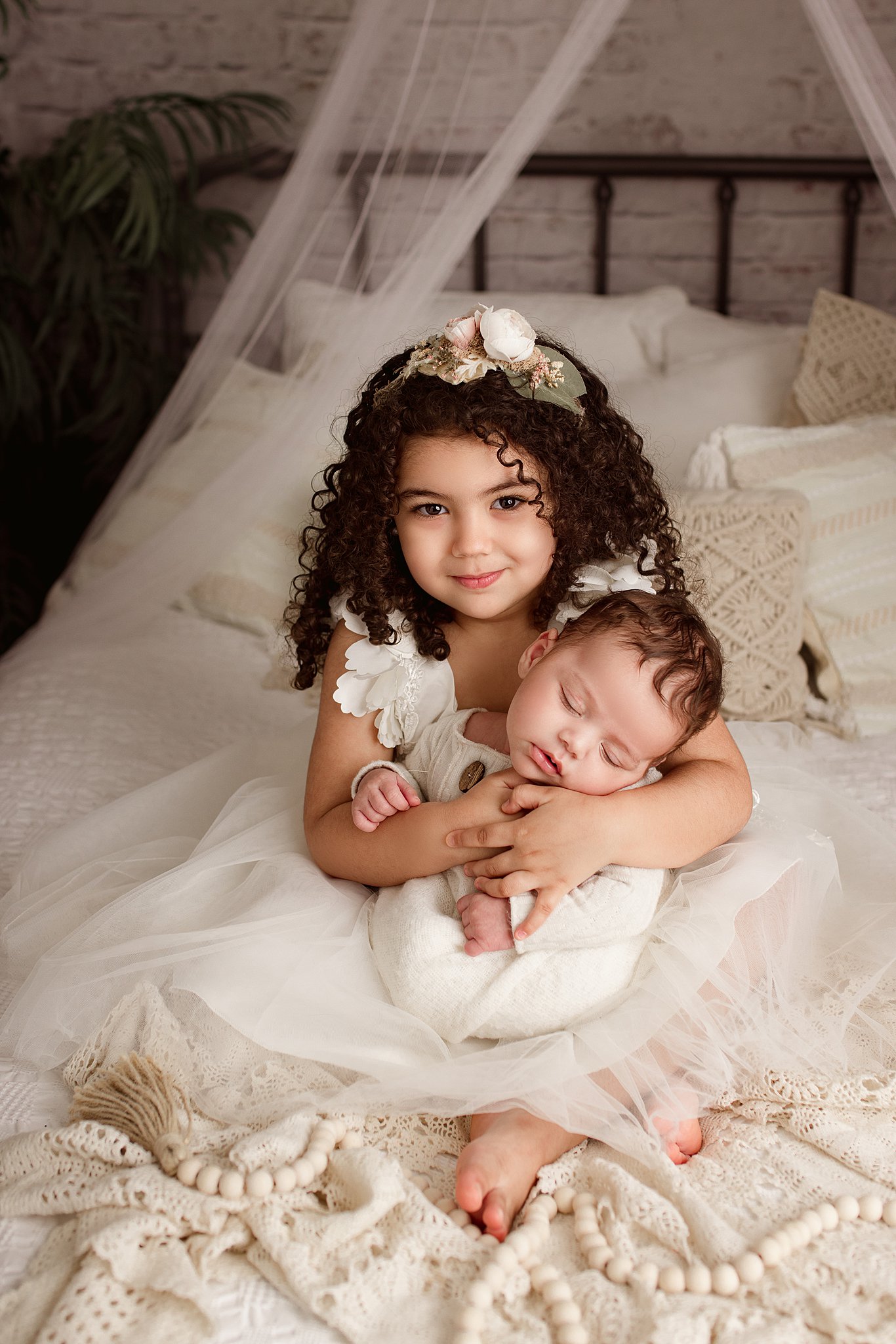 little girl in white dress holding her newborn baby brother nanny services toronto