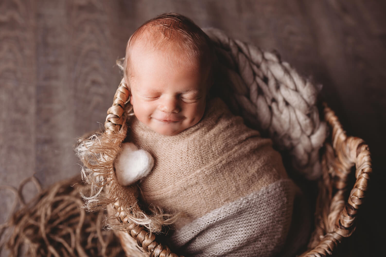Studio photo of newborn smiling.