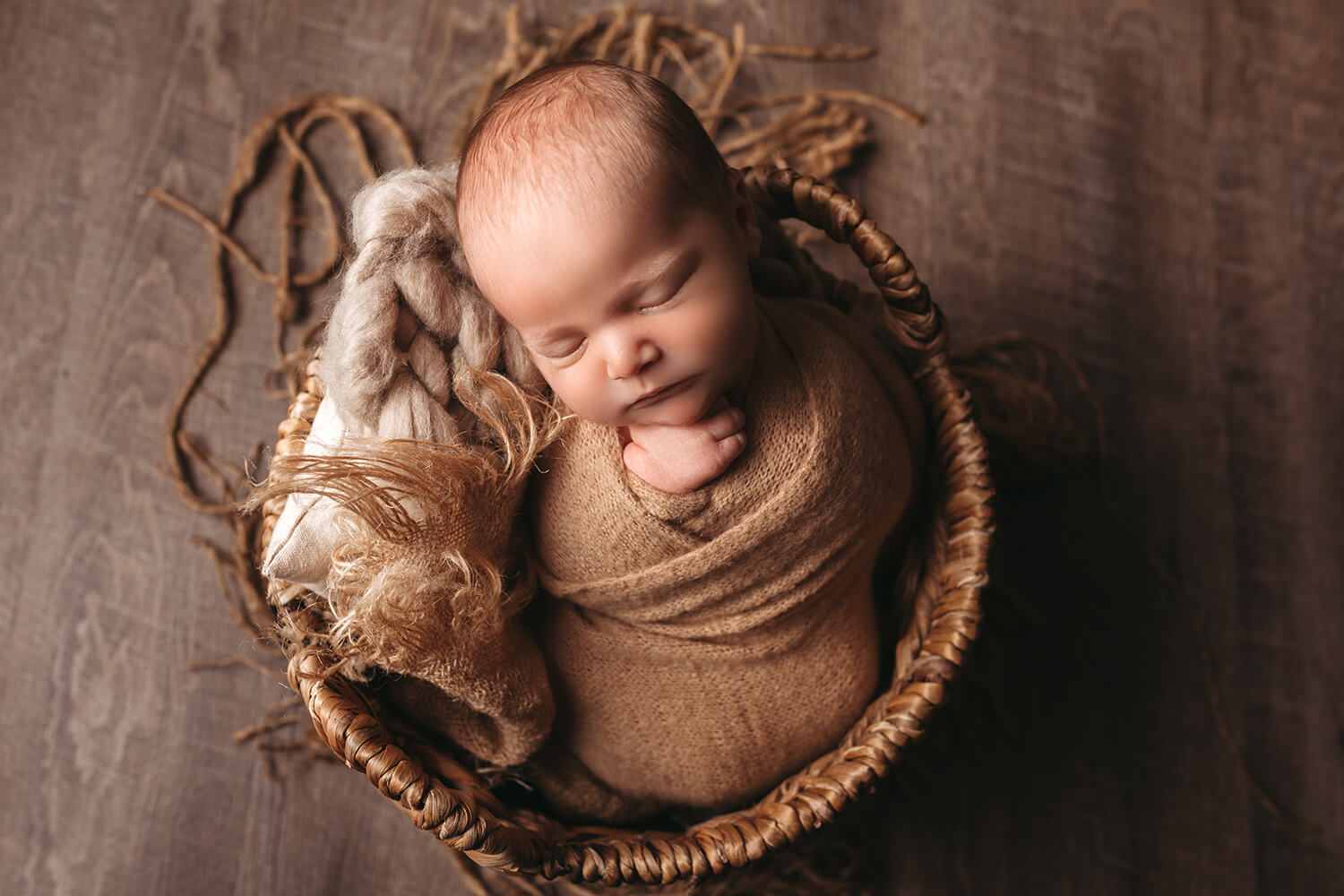 Studio photo of a newborn in a basket in studio.