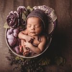 Photo of baby in decorated basket with wool hat.