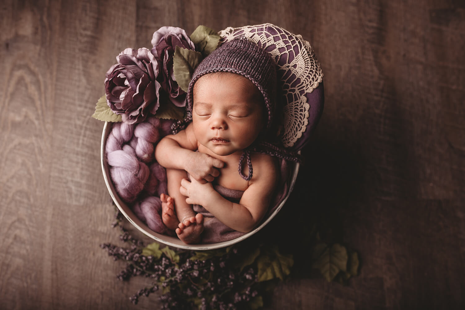 Photo of baby in decorated basket with wool hat.